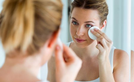 Woman with acne-prone skin cleaning her face Woman with acne-prone skin cleaning her face