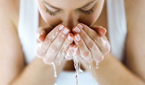 Woman washing her face with water